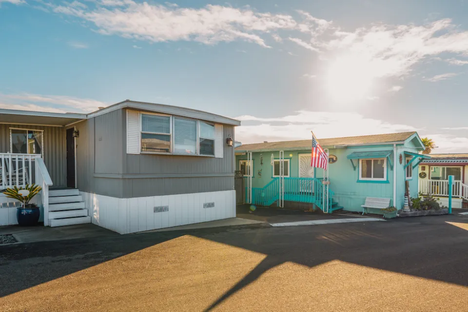 Row of colorful mobile homes on an asphalt street.